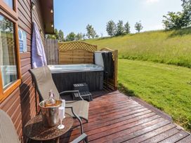 An outdoor patio with a hot tub and seating area at 16 Badgers Retreat in Richmond