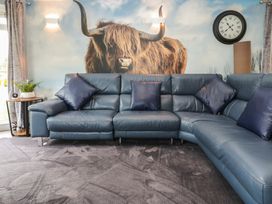 A living room with a blue sofa and wall art at 16 Badgers Retreat Richmond