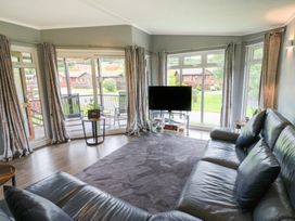 A living room with a television and sofa at 16 Badgers Retreat in Richmond