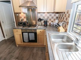 A kitchen with a gas stove and sink at 16 Badgers Retreat in Richmond