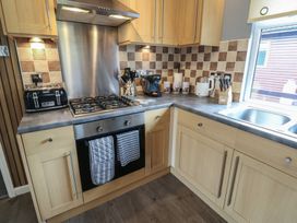 A kitchen with cabinets, stove, and sink at 16 Badgers Retreat in Richmond