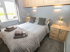 A bedroom with a bed and bedside table at 16 Badgers Retreat in Richmond