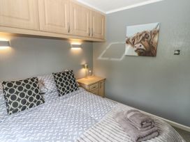 A bedroom with a bed, bedside table and lamp at 16 Badgers Retreat in Richmond