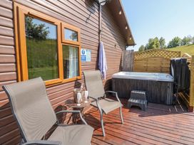 An outdoor area with a hot tub and chairs at 16 Badgers Retreat in Richmond