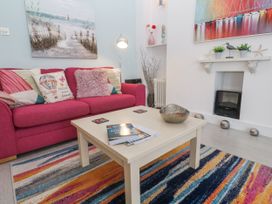 A living room with a pink sofa and coffee table at Beachcomber in Marazion