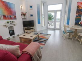 A living room with a television and dining table at Beachcomber in Marazion