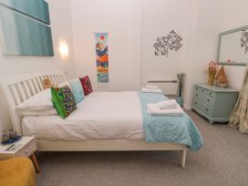 A bedroom with a bed and dresser at Beachcomber in Marazion