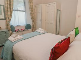 A bedroom with a bed and wardrobe at Beachcomber in Marazion