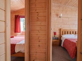 A bedroom with two beds and a window at The Cabin at East Hill Pride in Four Elms Hill Nr. Sidmouth