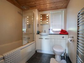 A bathroom with a shower over bathtub and sink at The Cabin at East Hill Pride Four Elms Hill Nr. Sidmouth