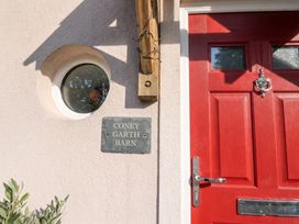 A red front door with a nameplate at Coney Garth Barn in Beckermet