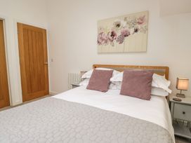 A bedroom with a bed and a painting at Coney Garth Barn in Beckermet