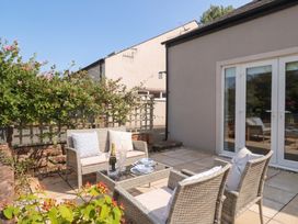 An outdoor seating area with a table and wine at Coney Garth Barn Beckermet