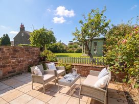 A garden with a patio seating area at Coney Garth Barn in Beckermet