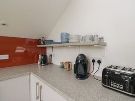 A kitchen with appliances and crockery at Coney Garth Retreat in Beckermet