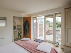 A bedroom with a bed and sliding doors at Coney Garth Retreat in Beckermet