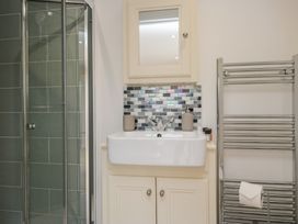 A bathroom with a shower, sink, and towel rail at Coney Garth Retreat in Beckermet