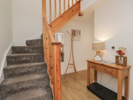 A hallway with stairs and a console table at Coney Garth Retreat in Beckermet