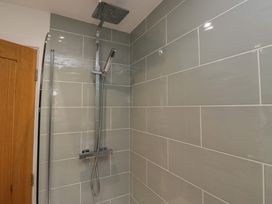 A shower with tiles and fittings at Coney Garth Retreat in Beckermet
