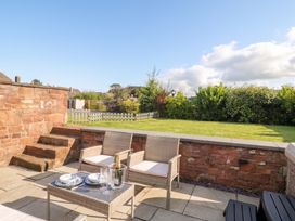 A garden with chairs and a table in Coney Garth Retreat Beckermet