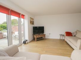 A living room with a television and two sofas at Coney Garth Cottage in Beckermet