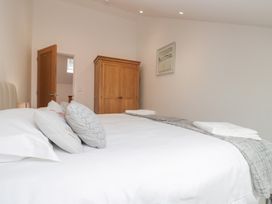 A bedroom with a bed and wardrobe at Coney Garth Cottage in Beckermet