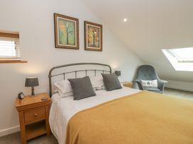 A bedroom with bed and bedside table at Coney Garth Cottage Beckermet