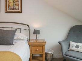 A bedroom with a bed and nightstand at Coney Garth Cottage in Beckermet