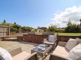 A garden with outdoor seating and tableware at Coney Garth Cottage in Beckermet