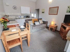 A living room with a sofa and kitchen area at Carters in Staintondale