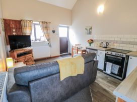 A living room with a sofa and kitchen area at Carters in Staintondale