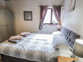 A bedroom with a bed and wardrobe at Carters in Staintondale