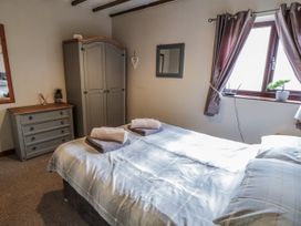A bedroom with a bed, wardrobe, and a window at Carters in Staintondale