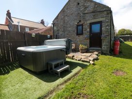 A garden with a hot tub and a building at Carters in Staintondale near Burniston
