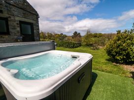 A hot tub with a view of trees and seating area at Carters Staintondale near Burniston