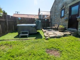 A garden with a hot tub and seating area at Carters in Staintondale near Burniston