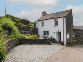 A house with gravel area and stone wall at Rose Cottage in Broughton-In-Furness
