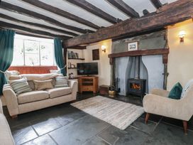 A living room with a sofa and wood burner at Rose Cottage Broughton-In-Furness