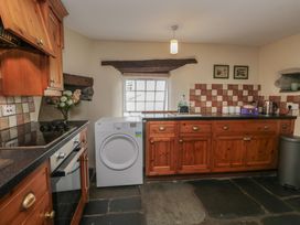 A kitchen with cabinets and appliances at Rose Cottage in Broughton-In-Furness