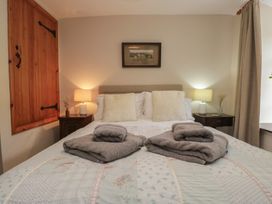 A bedroom with a bed and nightstands at Rose Cottage in Broughton-In-Furness