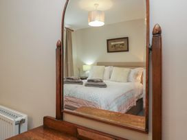 A bedroom with a mirror showing a bed at Rose Cottage in Broughton-In-Furness