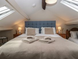 A bedroom with a bed and bedside table at Rose Cottage in Broughton-In-Furness