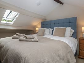 A bedroom with a bed and bedside lamp at Rose Cottage in Broughton-In-Furness
