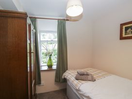 A bedroom with a bed and a wardrobe at Rose Cottage in Broughton-In-Furness
