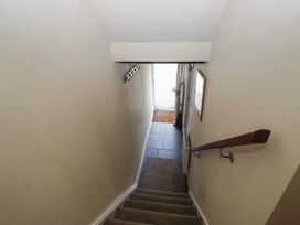 A staircase with a handrail leading to a door at Rose Cottage in Broughton-In-Furness