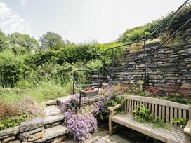 A garden with steps and a wooden bench at Rose Cottage in Broughton-In-Furness