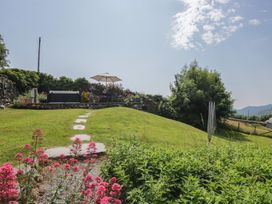 A garden with a seating area and flowers at Rose Cottage in Broughton-In-Furness