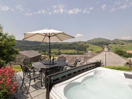 An outdoor area with a hot tub, table, and chairs at Rose Cottage in Broughton-In-Furness