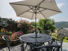 An outdoor seating area with a table and umbrella at Rose Cottage in Broughton-In-Furness