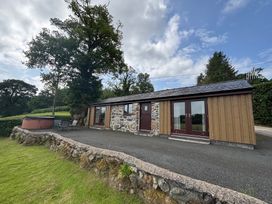 A cottage with a hot tub and outdoor seating at Bothi in Llanuwchllyn